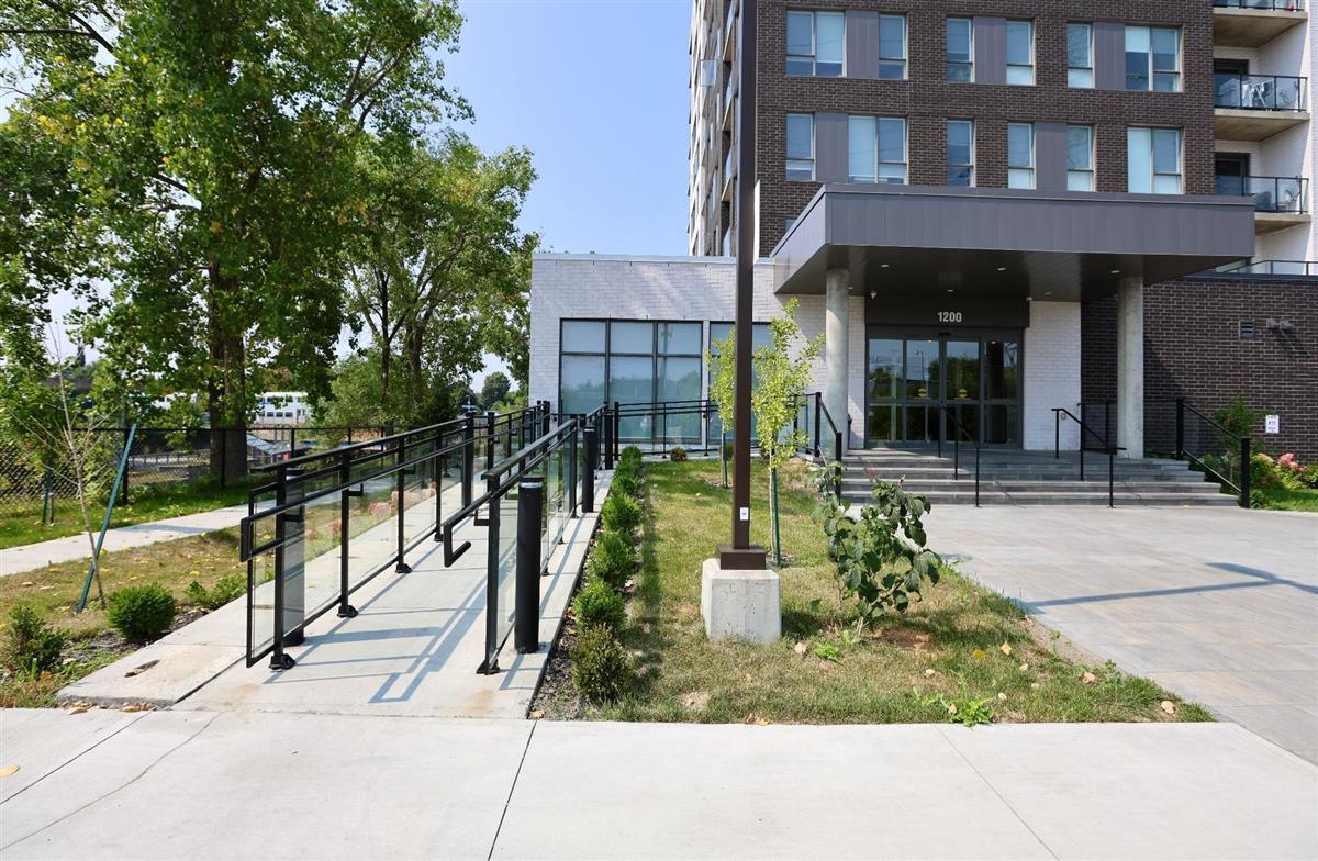 Entrance to a condo building in Montreal with an access ramp and glass lobby